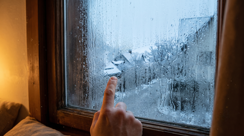 A bedroom window covered in thick morning condensation