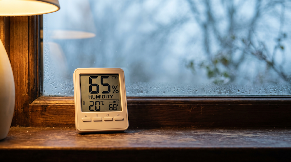 A digital hygrometer on a windowsill